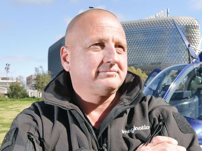 Shane Yeend in front of the helicopter in the proposed space for a helipad behind the new Royal Adelaide Hospital in Adelaide, Friday, September 8, 2017. (AAP Image/Morgan Sette)