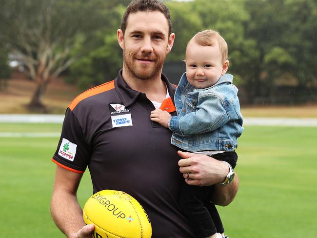 Shane Mumford after announcing his retirement from AFL, with his 11-month-old son Ollie. Picture: Brett Costello