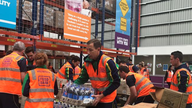 NRL referee Ben Cummins packing groceries for charity