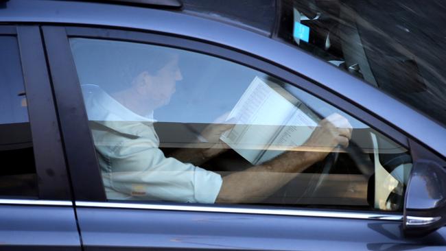 A man reads a book on Manly Rd yesterday. Picture: John Grainger