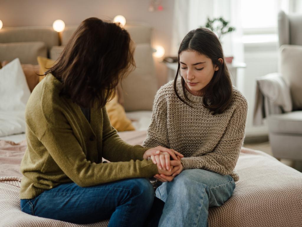 Teenage girl sharing problems with her mother in the room.