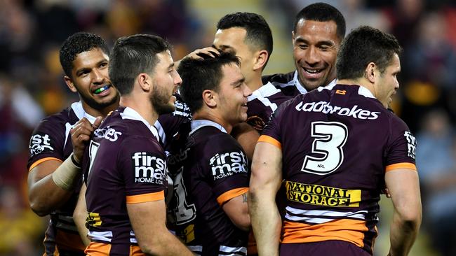 Broncos players celebrate a try against the Bulldogs.