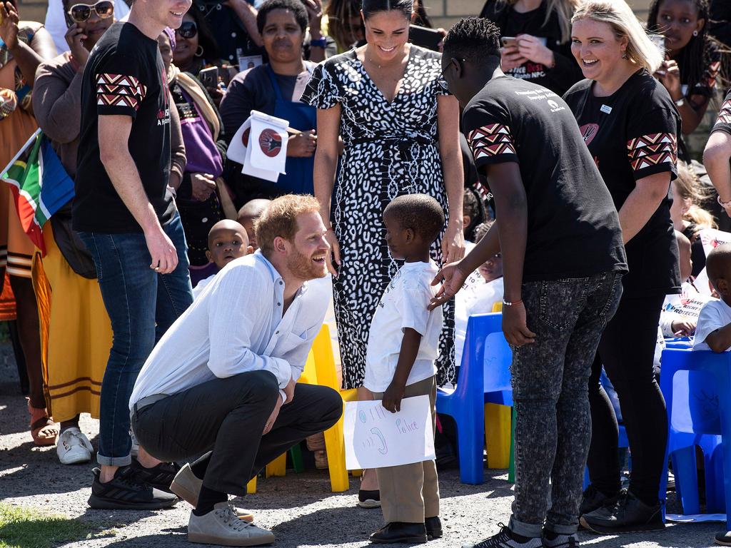 The boy gave a gift to the Duke and Duchess of Sussex as they arrived at Justice desk. Picture: David Harrison/AFP