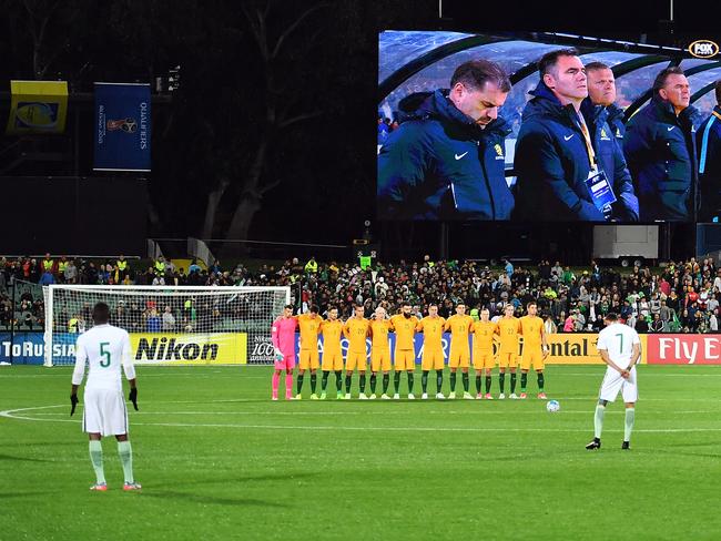 Socceroos players, coaching staff and fans observe a moments silence at the Adelaide Oval.