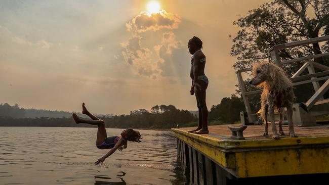 Mingling Waters Caravan Park, which backs on to the Snowy River, has suffered a dramatic drop in visitor numbers caused by the bushfires. Bethany, 6, and Laurena, 8, splash in the river. Picture: Alex Coppel..