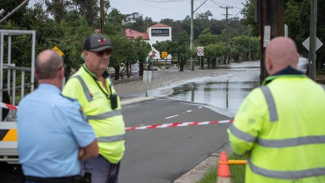 Floodwater crossing the Cowpasture Bridge in Camden cuts the community in half. Picture: Julian Andrews