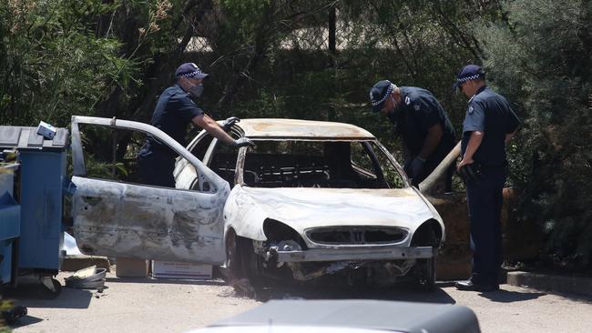 Police examine Ms Chetcuti’s burnt out car.