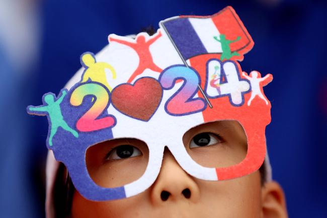 TOPSHOT - PARIS, FRANCE - JULY 26: A spectator is seen wearing glasses in the colours of the France national flag during the opening ceremony of the Olympic Games Paris 2024 on July 26, 2024 in Paris, France. (Photo by Steph Chambers / POOL / AFP)