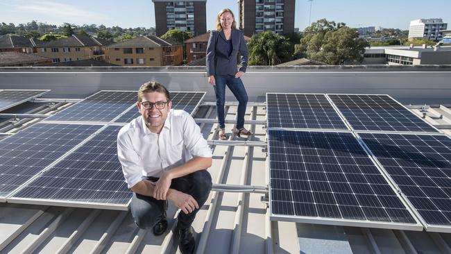 Ryde mayor Jerome Laxale (L) and Cr Edwina Clifton (R) with solar panels on the roof of Ryde Community Centre at West Ryde on Friday. (AAP IMAGE / Troy Snook)