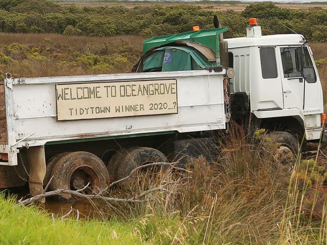 An abandoned truck now has humorous sign attached "Welcome to Ocean Grove" Tidytown winner 2020..?" . The truck ran off the road on October 20 and is deeply embedded in State Game Reserve mangroves off Wallington Road. There was an attempt to unload it and remove it a few weeks ago but it still lies where it came to rest two and a half months ago. Picture: Alan Barber