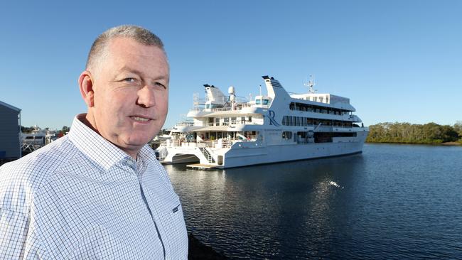 Gold Coast City Marina and Shipyard director Trenton Gay standing in front of a 60-metre superyacht being worked on at the marina at Coomera. Dredging will only help business at the marine precinct. Picture Glenn Hampson