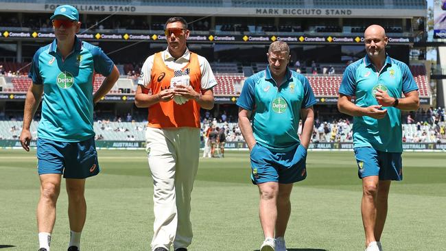 ADELAIDE, AUSTRALIA - JANUARY 18: Andrew McDonald, head coach of Australia, Scott Boland, Scott Burns and Matthew Nicks of the Adelaide Crows Football Club walk from the field at the tea break during day two of the First Test in the Mens Test match series between Australia and West Indies at Adelaide Oval on January 18, 2024 in Adelaide, Australia. (Photo by Paul Kane/Getty Images)