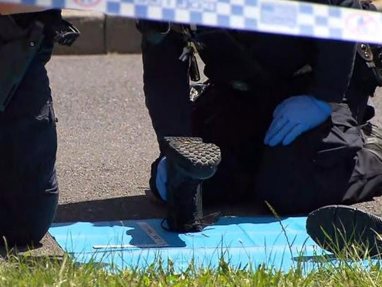 Police paid close attention to a pair of black work boots left on the road. Picture: Seven News