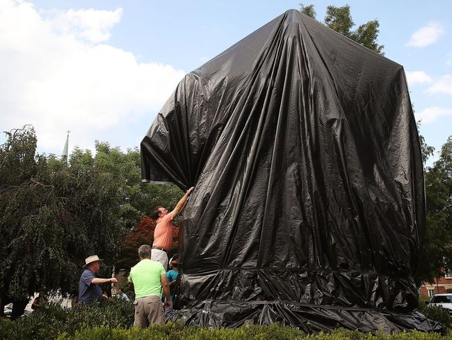 Workers repair a black sheet that was put over the statue of Robert E. Lee in Virginia after a man tried to cut it off.