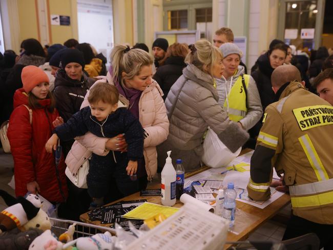 Ukrainians seek information on further destinations inside the main railway station in Przemysl, Poland. Approximately one and a half million people have arrived in Poland from Ukraine since the Russian invasion. Picture: Sean Gallup/Getty Images