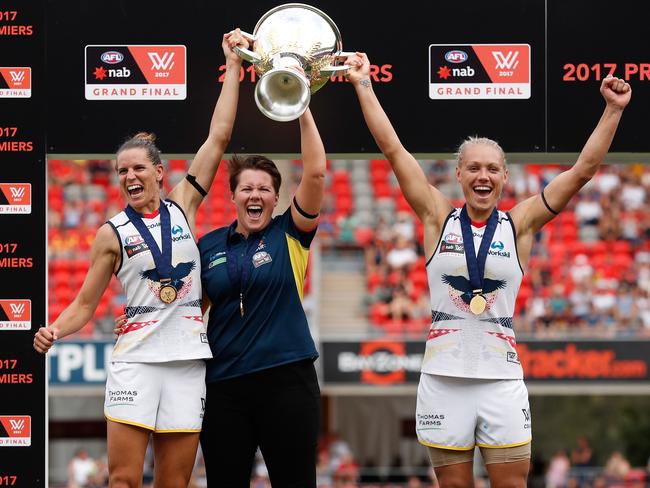 Chelsea Randall, Bec Goddard (Coach) and Erin Phillips of the Crows hold the cup.