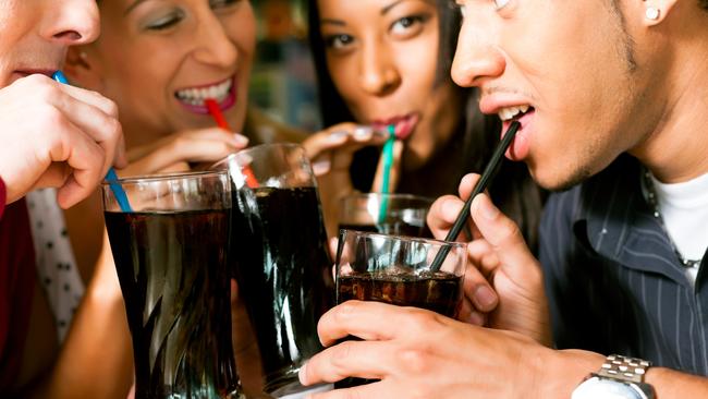 Four friends drinking soda in a bar with colorful straws