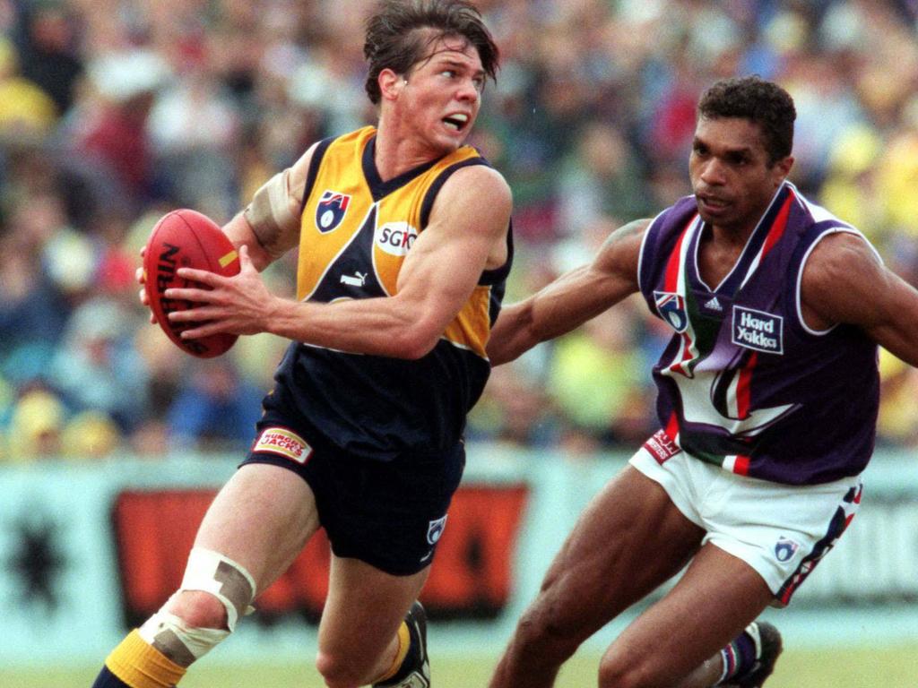 West Coast Eagles player Ben Cousins is chased by Fremantle Dockers player Scott Chisholm during a Western derby match in 1998.