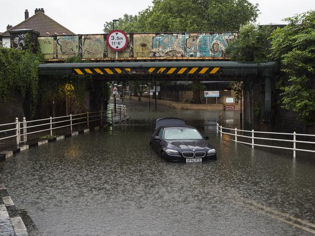 A car is abandoned under a bridge in Battersea, London, after getting stuck in floodwater following overnight thunderstorms in the south of England.