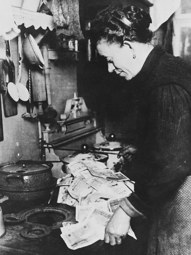 A German woman lights the morning fire in her stove with worthless paper money. Picture: Corbis via Getty Images