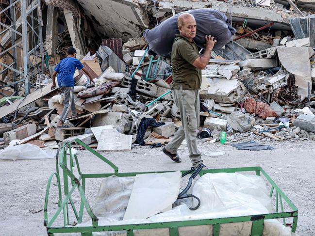 Palestinians look for salvageable items in the rubble of buildings destroyed during an Israeli air strike. (Photo by SAID KHATIB / AFP)