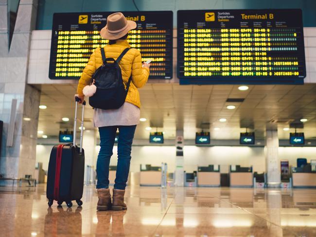 Young woman at the airport in Barcelona checking for the flight schedule