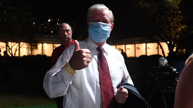 A masked Lindsey Graham gives a thumb's up at the White House. Picture: AFP