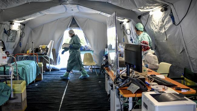 Medical personnel works inside one of the emergency structures that were set up to ease procedures outside Brescia hospital. Picture: Claudio Furlan/LaPresse