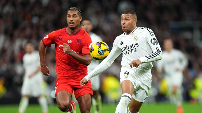 MADRID, SPAIN - DECEMBER 22: Kylian Mbappe of Real Madrid runs with the ball whilst under pressure from Loic Bade of Sevilla FC during the LaLiga match between Real Madrid CF and Sevilla FC at Estadio Santiago Bernabeu on December 22, 2024 in Madrid, Spain. (Photo by Angel Martinez/Getty Images)