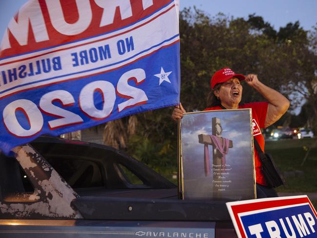 A supporter of Donald Trump sits in the back of a pickup truck outside the Florida State Fairgrounds where Joe Biden hosted his rally. Picture: Angus Mordant