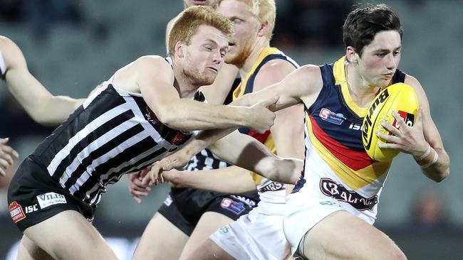 Port Adelaide Magpies’ Willem Drew tackles Adelaide’s Chayce Jones.