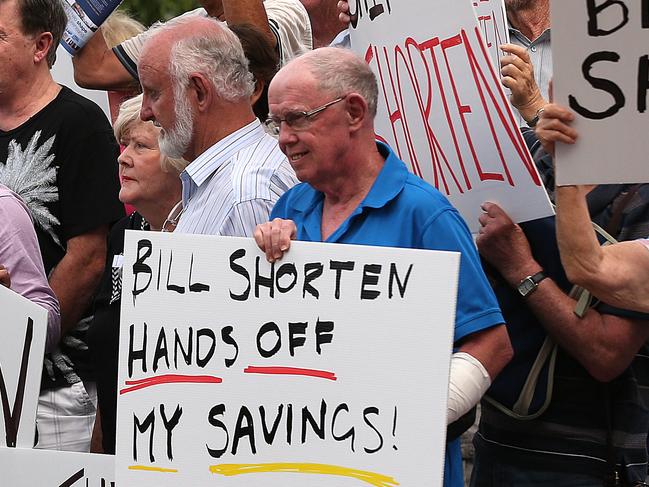 31/1/2019: Members of the public hold up supplied pre printed protest signs for a photograph, outside after a Senate Committee hearing at Upper Coomera on the Gold Coast. The couple are very concerned at the possibility of the Labor parties change in franking credits rules will affecting their lifestyle. Lyndon Mechielsen/The Australian