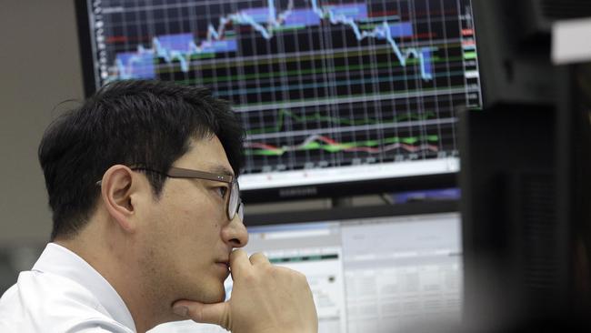 A currency trader watches monitors at the foreign exchange dealing room of the KEB Hana Bank headquarters in Seoul, South Korea, Wednesday, Sept. 23, 2015. Asian stock markets declined Wednesday as a global sell-off given impetus by the Volkswagen emissions scandal was exacerbated by weak Chinese factory data.(AP Photo/Ahn Young-joon)