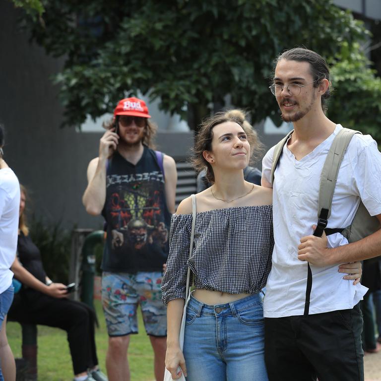 Will Mcalpin 22 and Carla Christou 20 from Labrador join lines of people waiting at Southport Centrelink after losing their jobs. Picture: Adam Head.