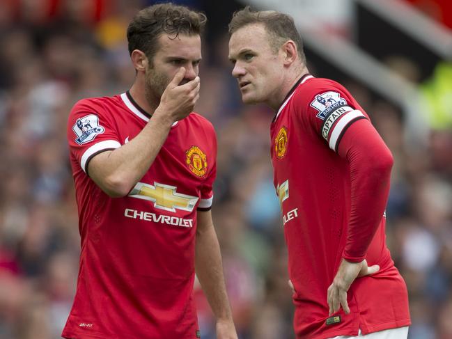 Manchester United's Wayne Rooney, right, confers with teammate Juan Mata as they prepare for a free kick during their side's 2-1 loss to Swansea City in their English Premier League soccer match at Old Trafford Stadium, Manchester, England, Saturday Aug. 16, 2014. (AP Photo/Jon Super)