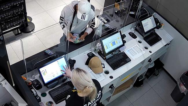 Darren Hookey counts cash at JD Sports in Westpoint Blacktown.