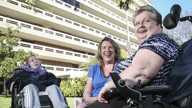 Disabilities SA boss Lynn Young (centre) with residents Tracey Gibb and Mary Edwards on the lawns in front of the main building. Picture: AAP