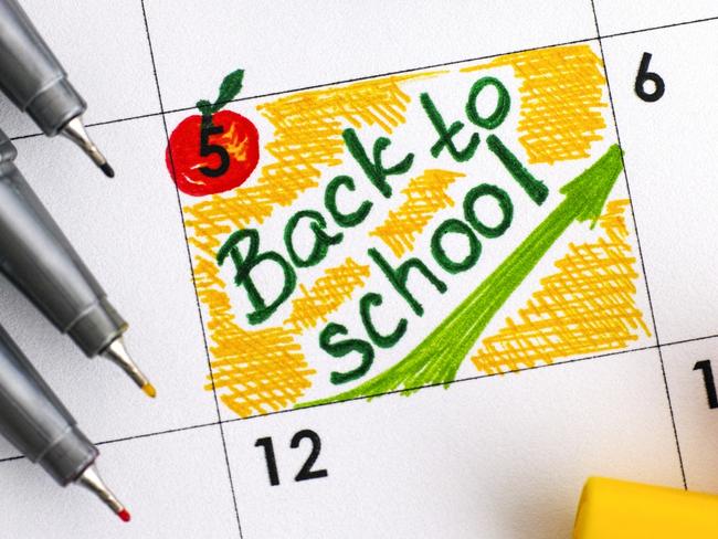 Reminder Back to School in calendar with colour pens. Close-up.
