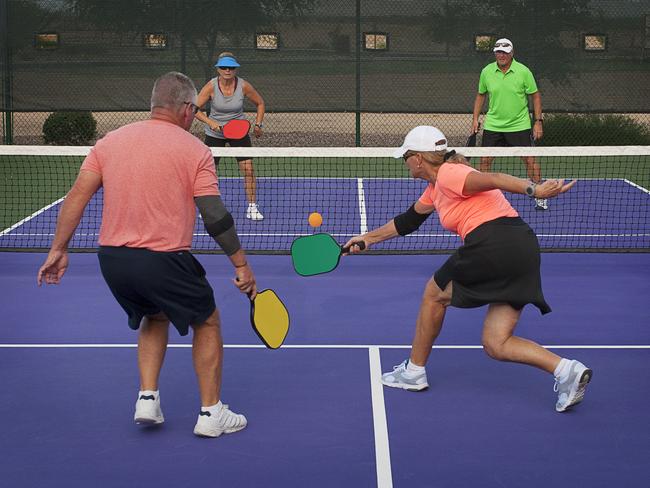 Colorful image of two teams playing Pickleball in a mixed doubles format.