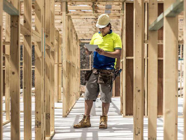 Developing Queensland - Construction worker on construction site, using digital tablet. He is checking if everything is ok.