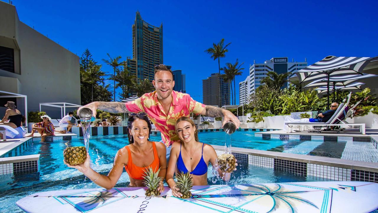 Vanessa Larkins and Tyra Eldridge poolside with QT Gold Coast’s cocktail king Brock Ashmore. Picture: NIGEL HALLETT