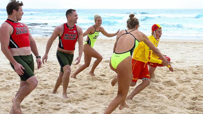 Harry Grant and Joel Selwood, Australian Iron Woman Champ and SLSA Hall of Fame Inductee Georgia Miller and Iron Women Harriet Brown are joined by Maroubra Lifeguards Tom Park and Matthew Park at Maroubra Beach in Sydney Picture: NCA Newswire / Gaye Gerard