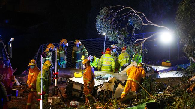 Fire crews work to remove a tree off a car in Terrys Ave, Belgrave after a heavy storm rolled through. Picture: Mark Stewart