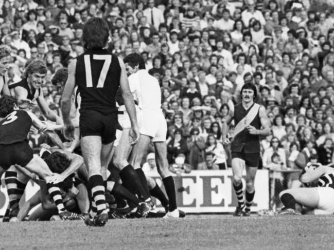 Footballer Brian Cunningham (top right) is down and his adversary, Wayne Phillis, has disappeared under a heap of players after the clash sparked a melee involving 28 players. SANFL football - Port Adelaide vs Glenelg second semi-final match at Football Park 12 Sep 1976. (Pic by staff photographer Bryan Charlton)