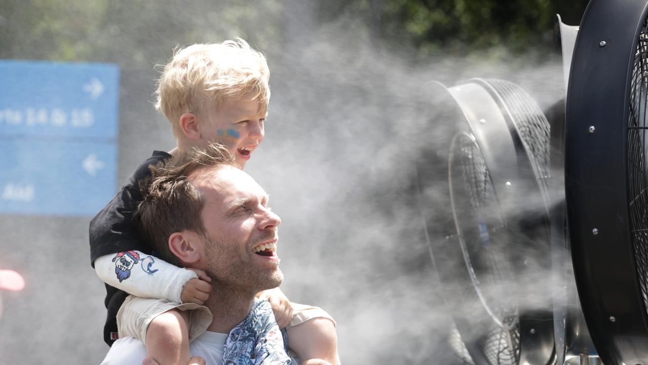 Nil Bergman from Sweden, cools off with young Olof 4 at the water spray fans. Picture: David Caird