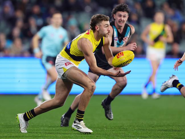 Sam Banks handballs for the Tigers. Picture: Sarah Reed/AFL Photos via Getty Images