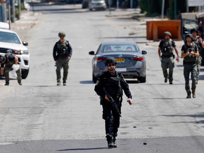 Members of Israeli security forces inspect sites where rockets launched from southern Lebanon fell in Kiryat Shmona in northern Israel. Picture: AFP