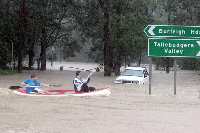 JUNE 30, 2005: Aaron Butler and Michael Henwood paddle along Tallebudgera Creek Road as rising floodwaters, the worst floods in 30 years hit the Gold Coast, 30/06/05