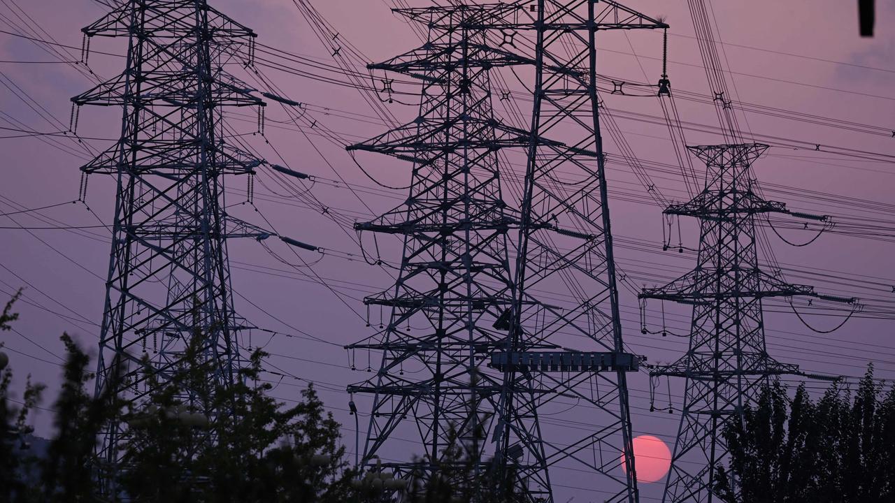 The sun sets behind electricity power pylons in Beijing. Picture: AFP