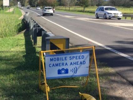 A mobile speed camera warning sign.